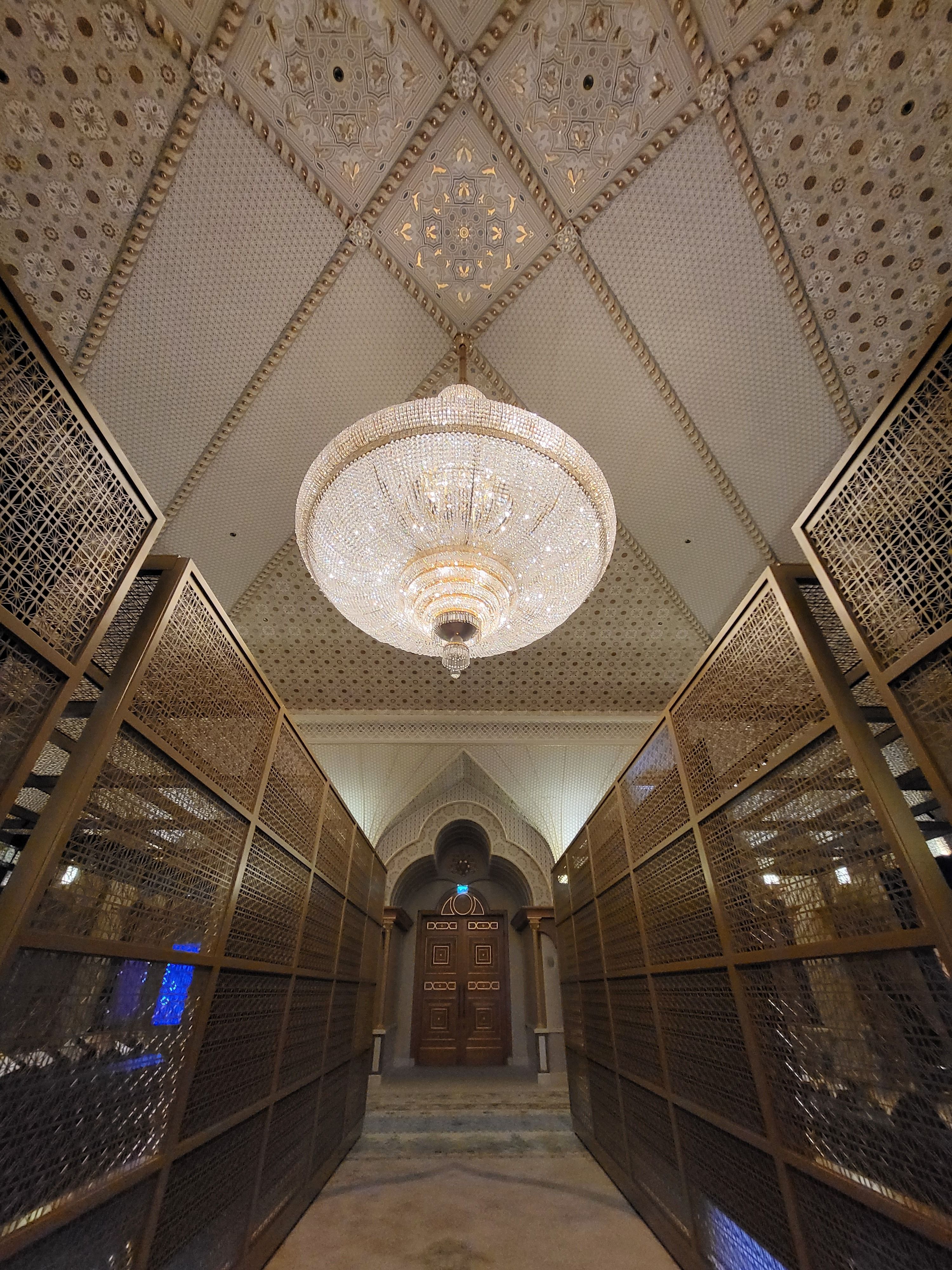 Elegant interior featuring a grand chandelier and intricate design, exuding luxury and grandeur.