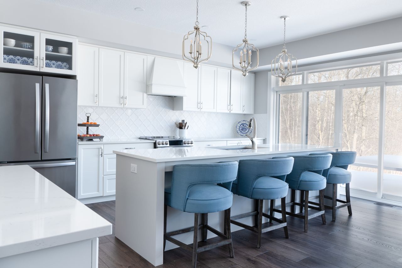 An island with a seating overhang and stools tucked under