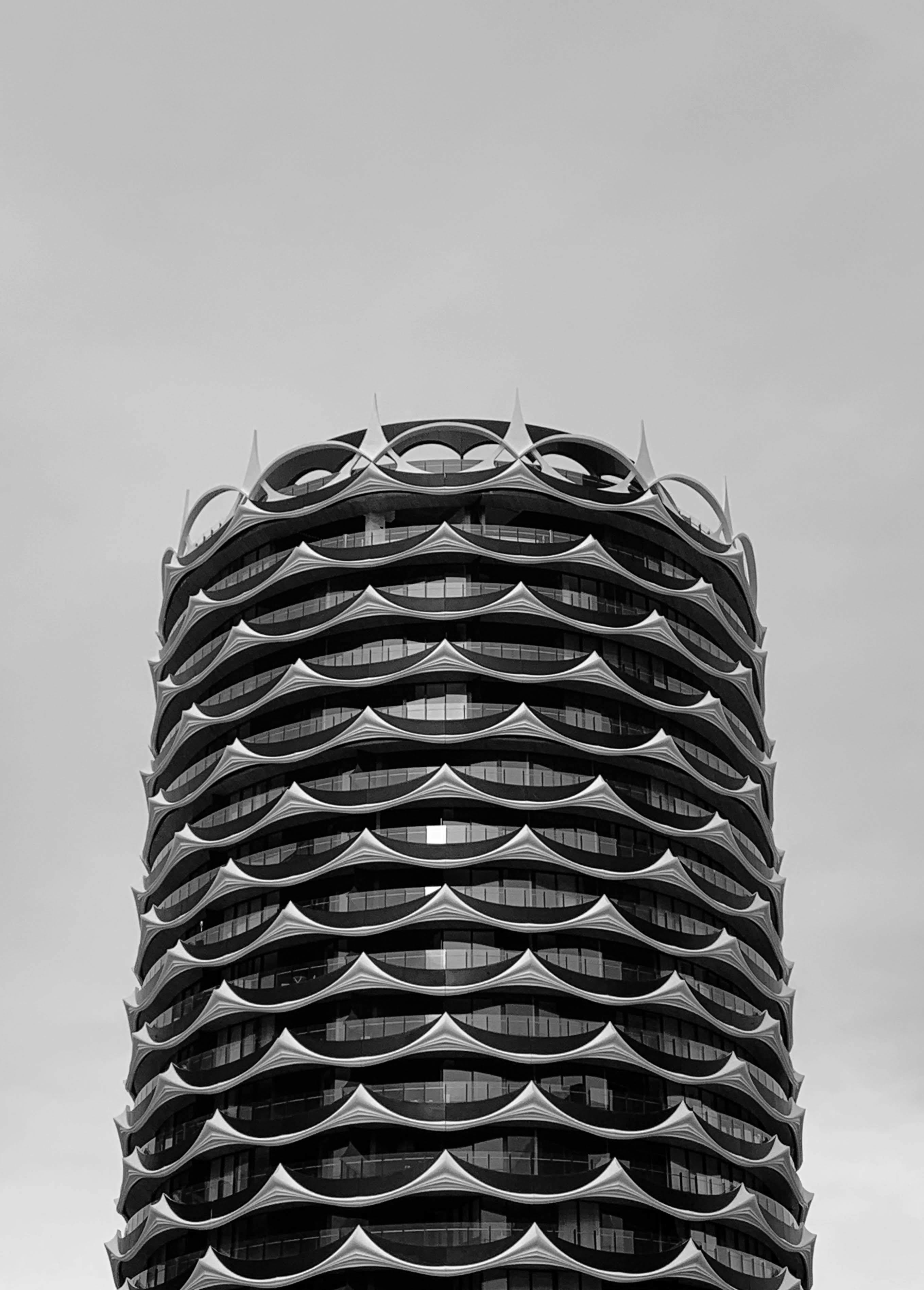Kostenlos Ein markanter, futuristischer Turm in Schwarz-Weiß, der sich durch ein einzigartiges architektonisches Design auszeichnet. Stock-Foto