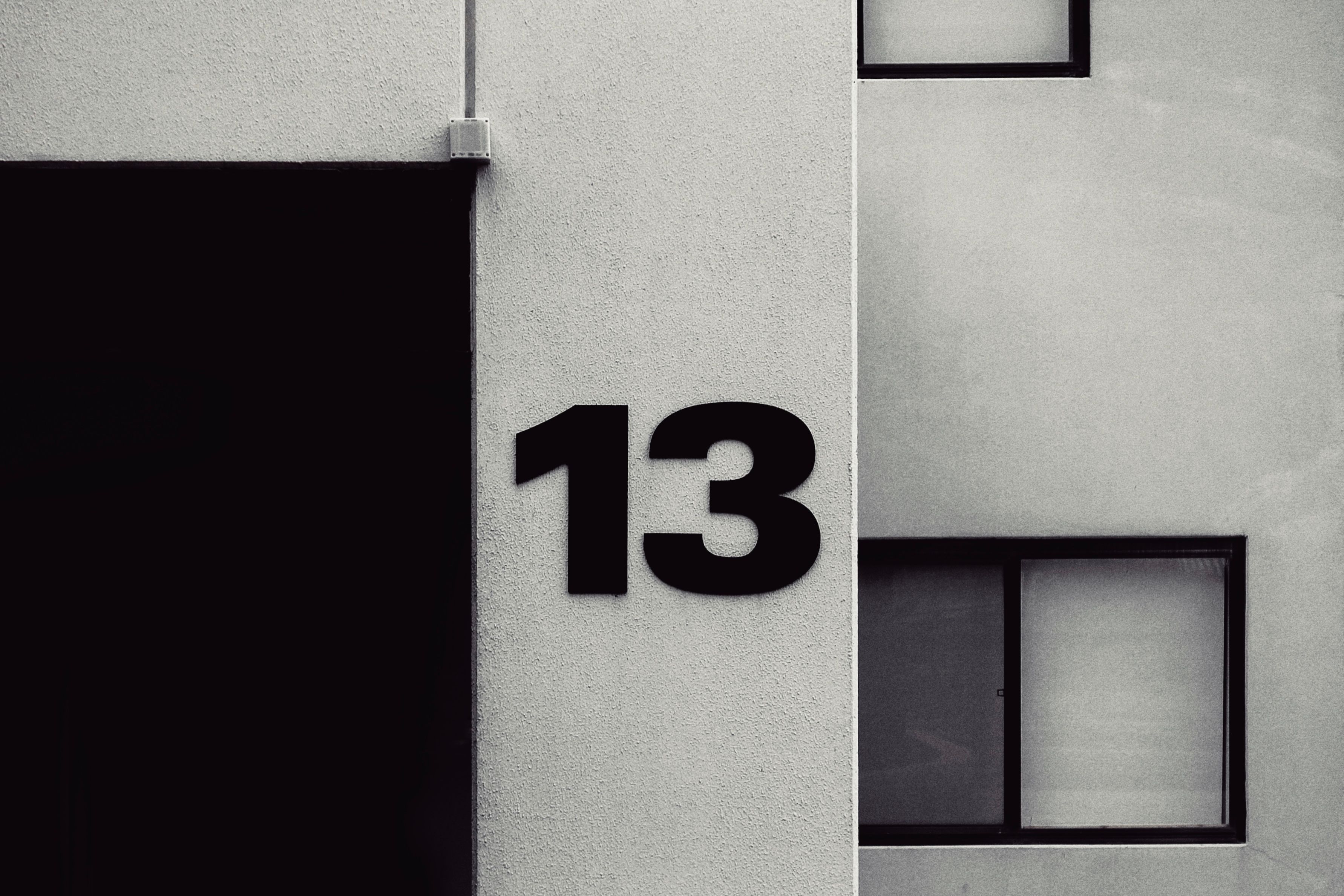 High-contrast facade featuring the number 13 on a modern building exterior.