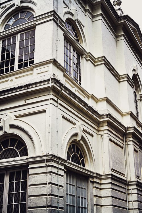 Free Close-up of a historic building with European architectural style featuring arched windows and ornate details. Stock Photo