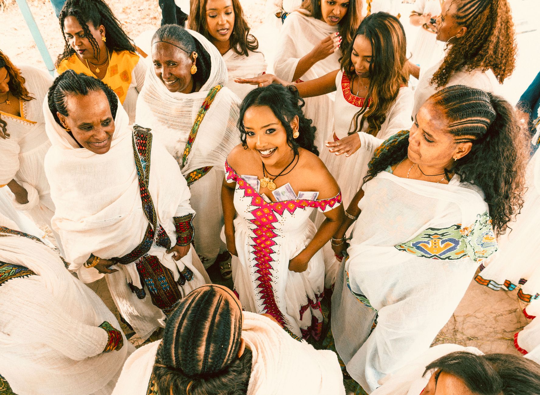A group of Ethiopian women joyfully celebrating in colorful traditional dresses, showcasing cultural heritage.