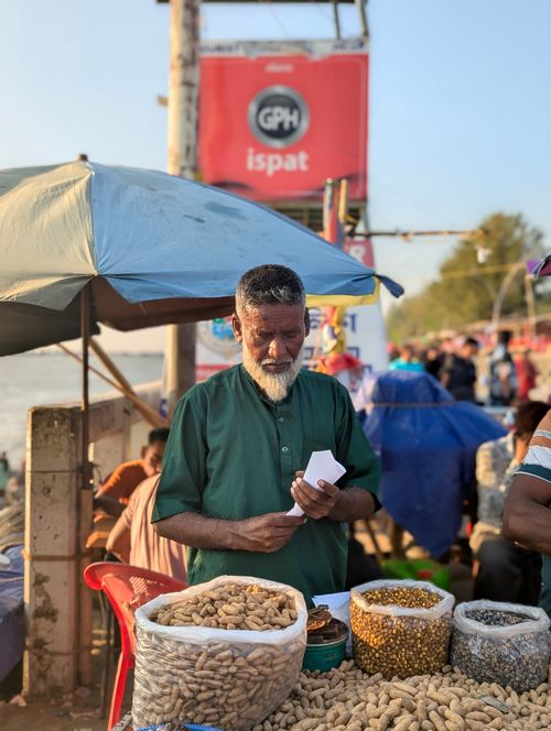 Free A street vendor selling peanuts at a lively market in Chittagong, Bangladesh. Stock Photo
