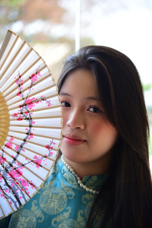 Free Woman in traditional attire holding a decorative fan. Stock Photo
