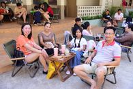 Happy family enjoying drinks at an outdoor cafe, relaxing and smiling together.