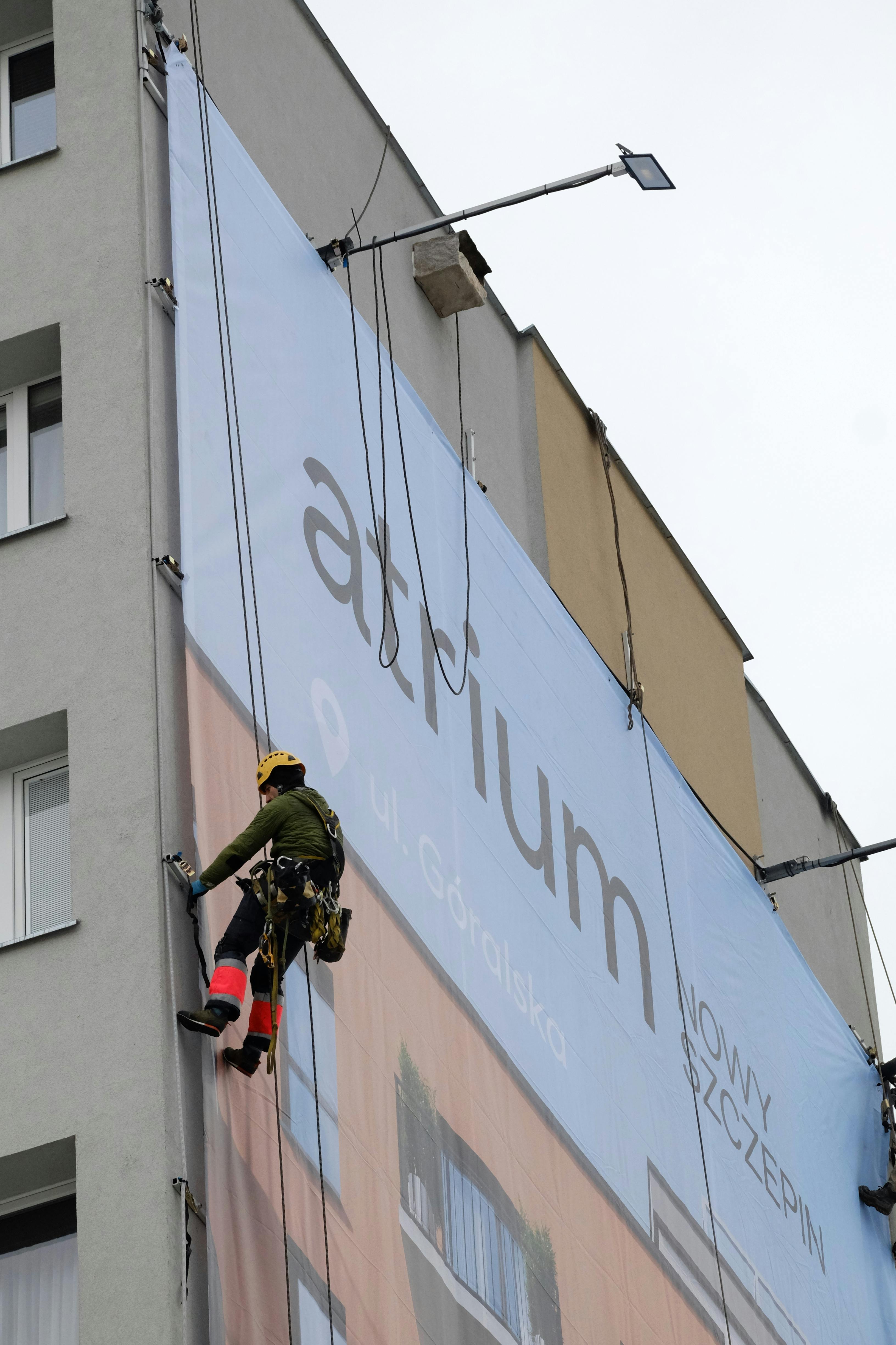 Professional window washer scaling the side of a high-rise building, displaying bravery and skill.