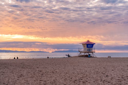 Ücretsiz Gün Batımı Sırasında Kumsaldaki İnsanlar Stok Fotoğraflar