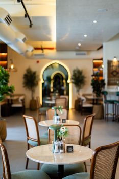 Stylish cafe interior in Dubai featuring elegant arch design and ambient lighting for a cozy dining experience.