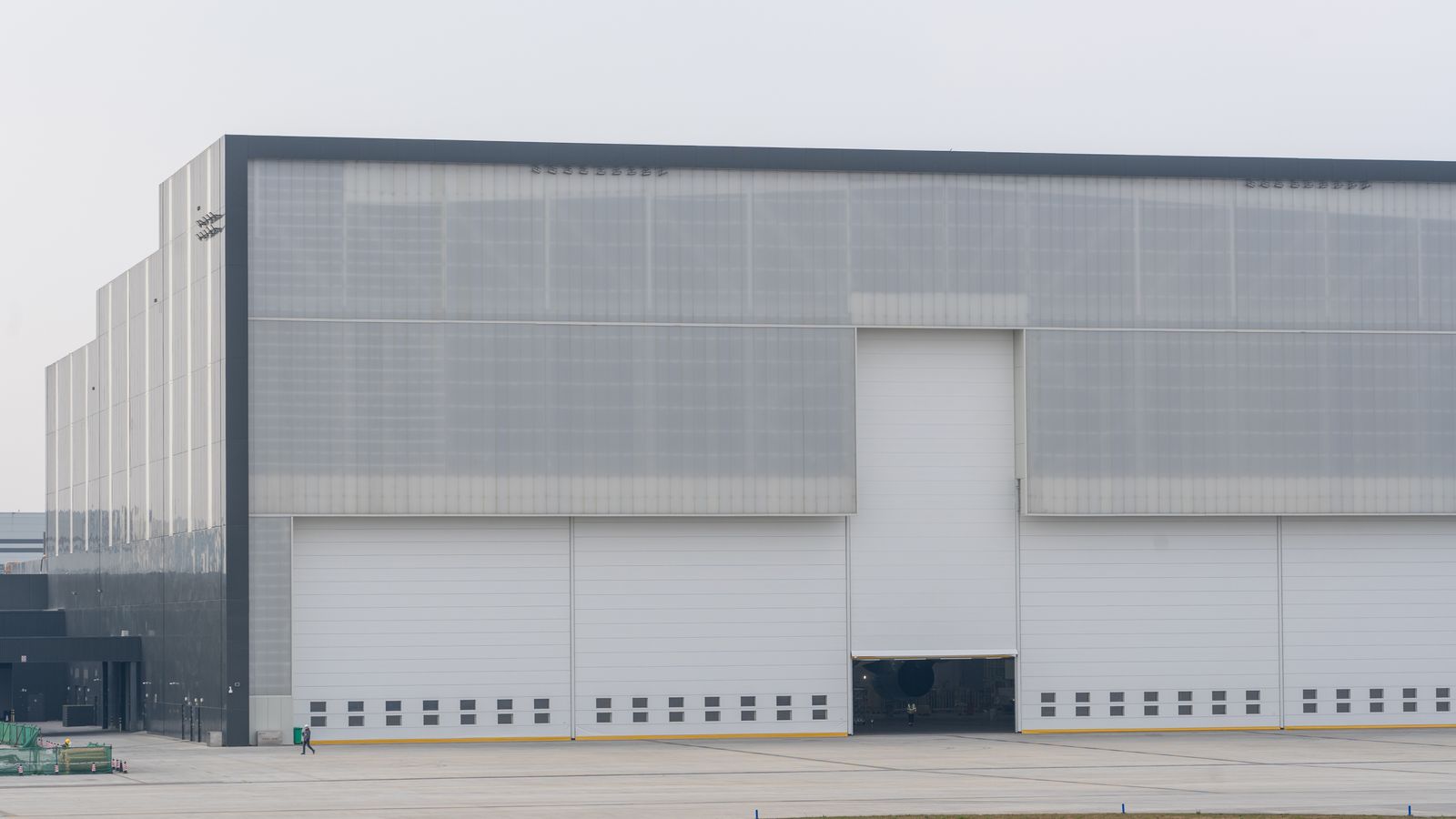 Front view of a large modern warehouse with closed doors, showcasing industrial architecture