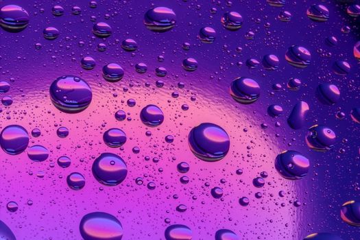 Abstract image of water droplets on a vibrant purple and pink surface, creating a modern artistic effect.