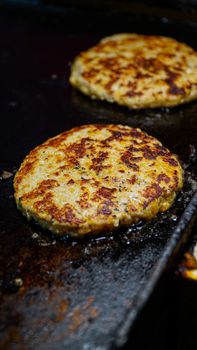 Close-up of sizzling burger patties cooking on a hot grill, perfect for BBQ themes.