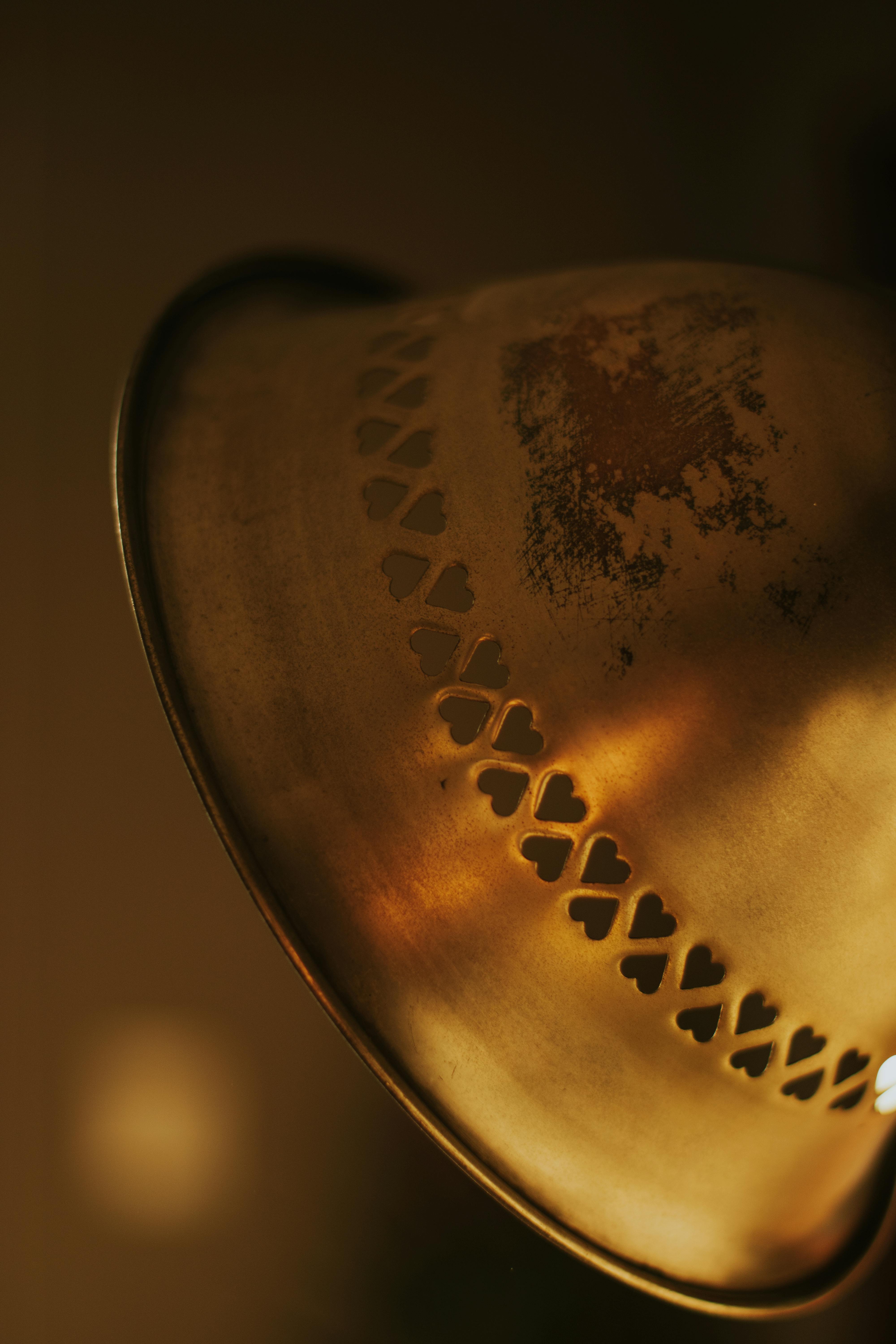 Miễn phí Ảnh cận cảnh một chiếc đèn bằng đồng cổ với các lỗ khoét hình trái tim, tỏa ra ánh sáng ấm áp. Ảnh lưu trữ