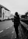 Person Standing on Roadside in Black and White