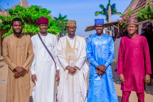 Free A group of five men in traditional attire standing outdoors, smiling at the camera. Stock Photo