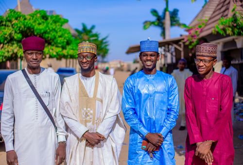 Free Four smiling men in traditional African attire pose outdoors in a vibrant setting. Stock Photo