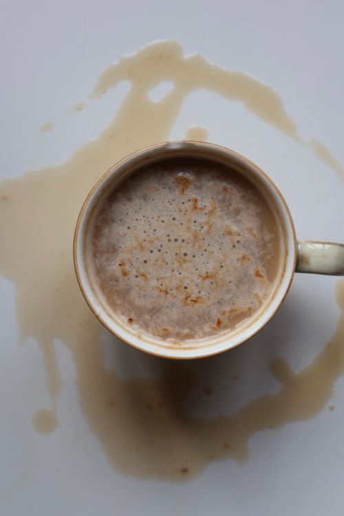 Free Top view of a coffee cup with spill stains on a white background, creating an abstract design. Stock Photo