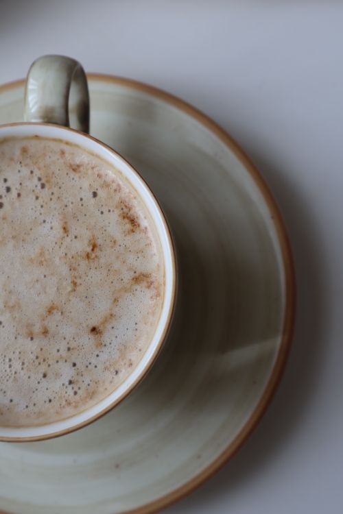 Free A close-up shot of a creamy coffee in a ceramic cup, ideal for coffee-themed designs. Stock Photo
