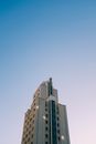 以清澈的蓝天为背景，低角度拍摄的现代建筑，突显了其设计特点