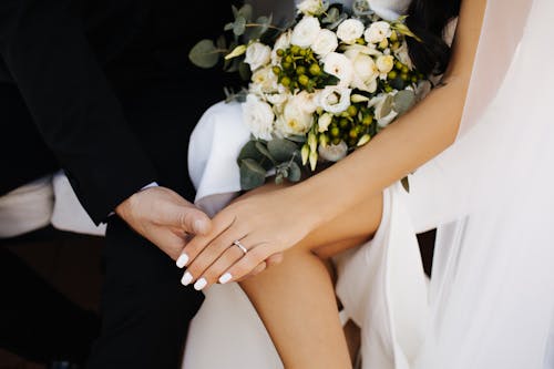 Woman in White Dress Holding White Flowers