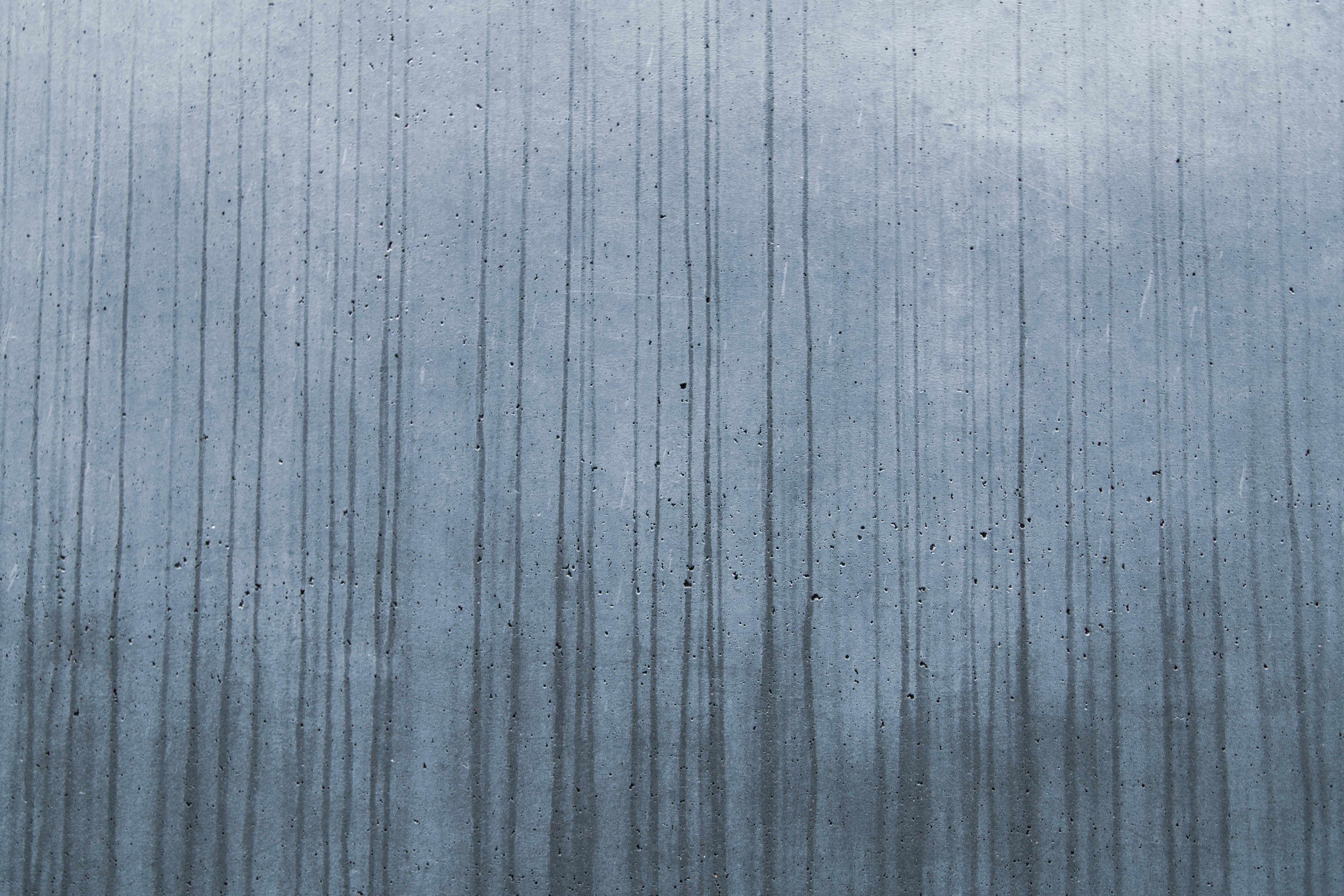 Free A textured concrete wall with streaking vertical lines creating an abstract pattern. Stock Photo