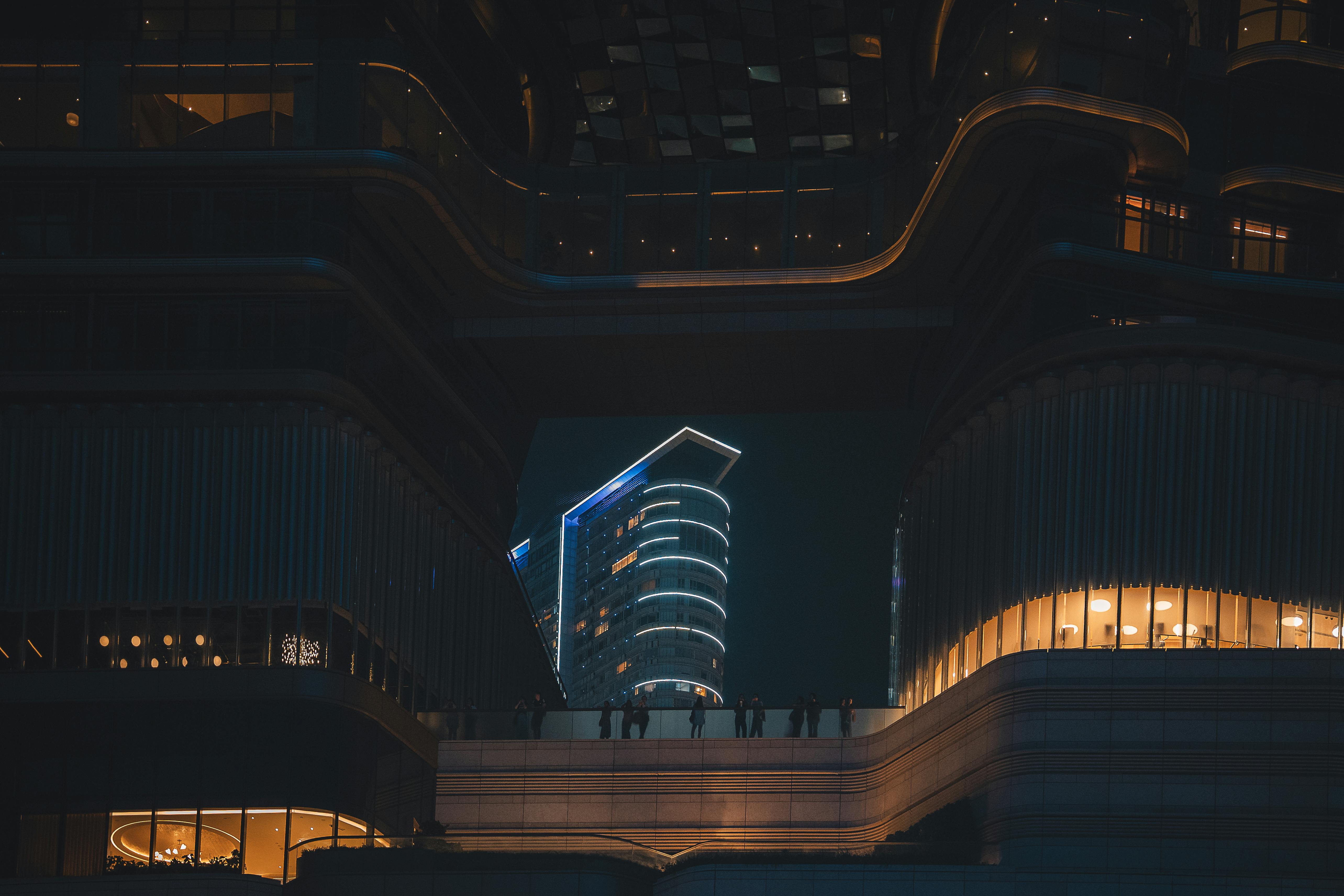 Безкоштовне Сучасна архітектура вночі в Гонконзі, що демонструє підсвічені футуристичні будівлі та міське життя. стокове фото