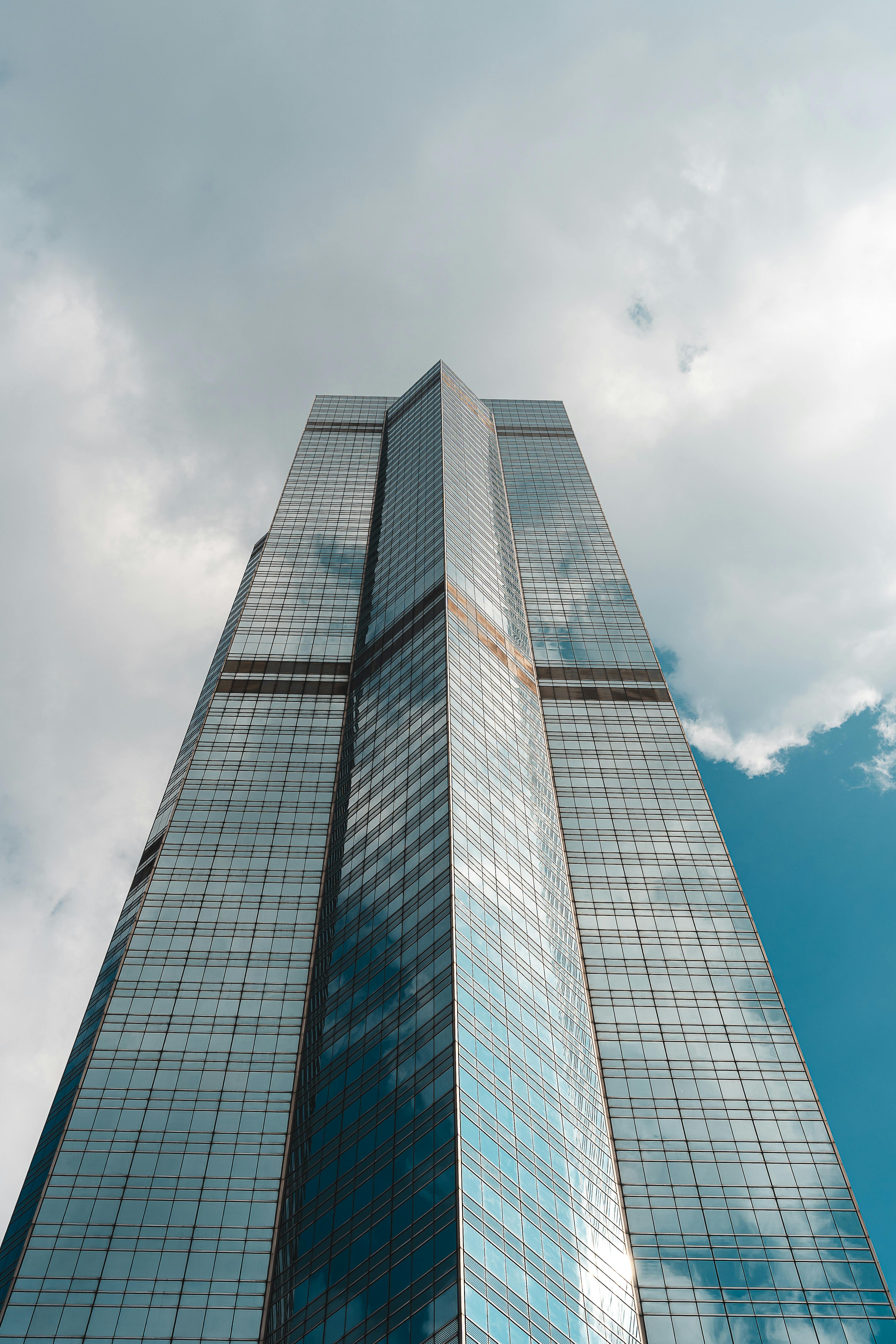 Ücretsiz Hong Kong'da modern bir gökdelenin görüntüsü; bulutlu gökyüzü cama yansıyor. Stok Fotoğraflar
