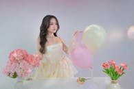 Woman in Elegant Dress with Balloons and Flowers