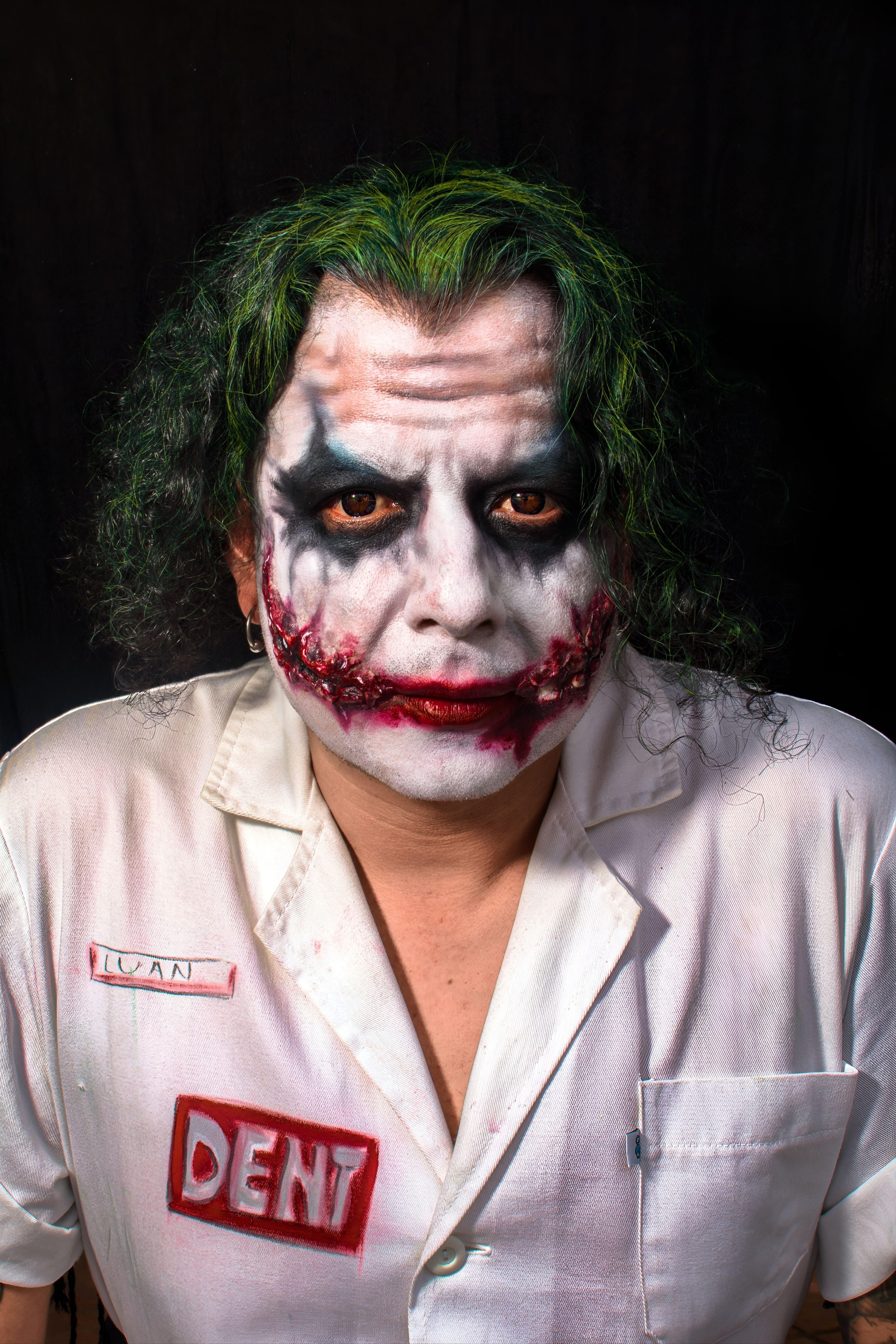 Close-up of a person in Joker cosplay with green hair and dramatic makeup.