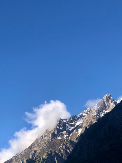 Free Stunning view of snow-covered mountain peaks against a vibrant blue sky, ideal for nature and travel themes. Stock Photo