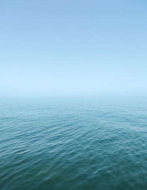Free Calm ocean view with gentle waves under a clear blue sky, exuding serenity and peace. Stock Photo