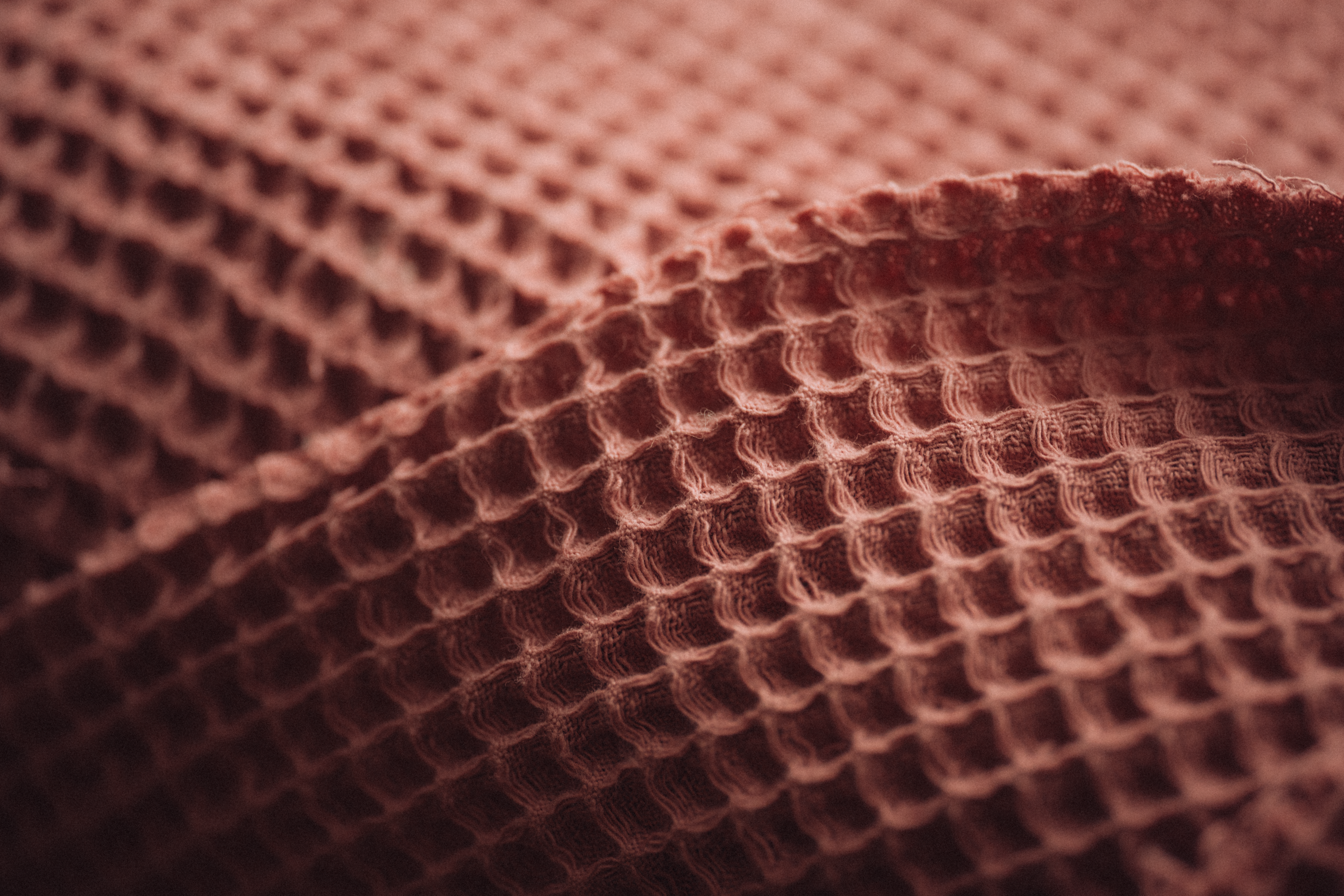 A stack of soft stonewashed linen waffle towels in natural ecru tones