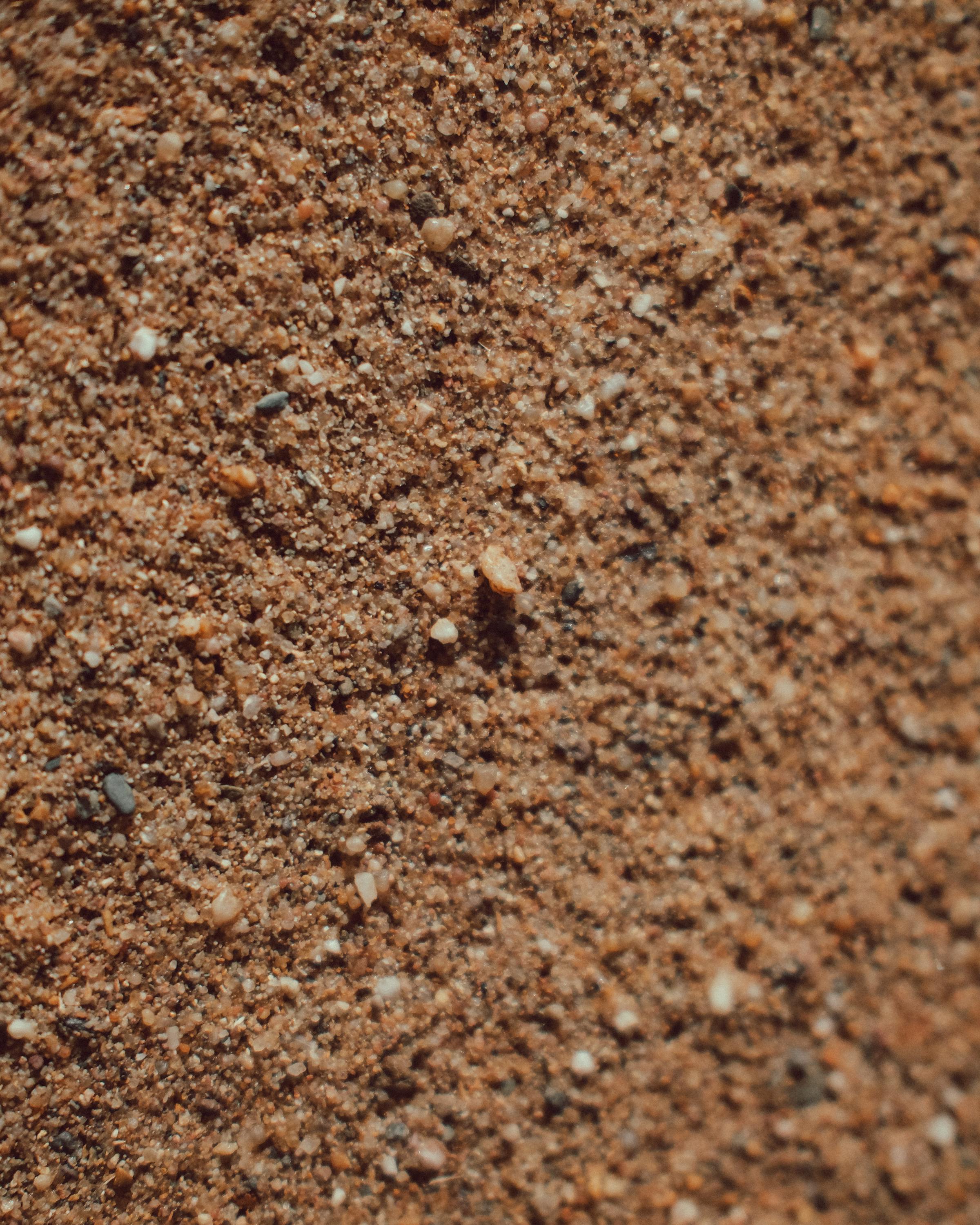 Free Close-up of coarse brown sand texture, ideal for backgrounds. Stock Photo