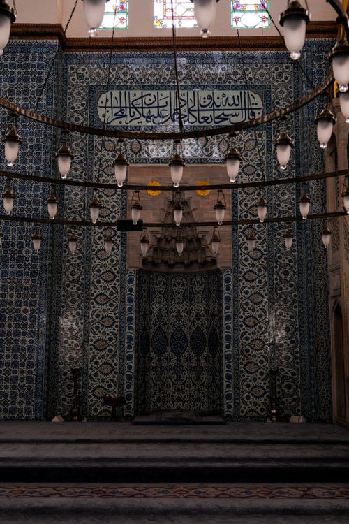Free Captivating interior of a historic mosque featuring intricate tiles and elegant chandeliers. Stock Photo