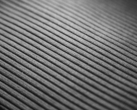 Monochrome close-up of a textured ribbed surface creating abstract lines.