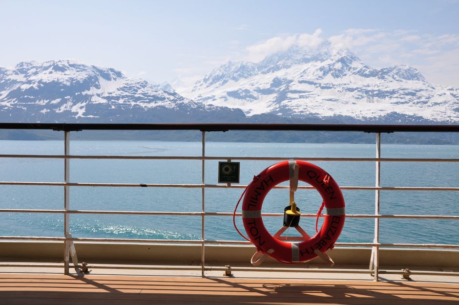 Scenic view of snowy mountains from a cruise ship in Alaska, highlighting nature's beauty.