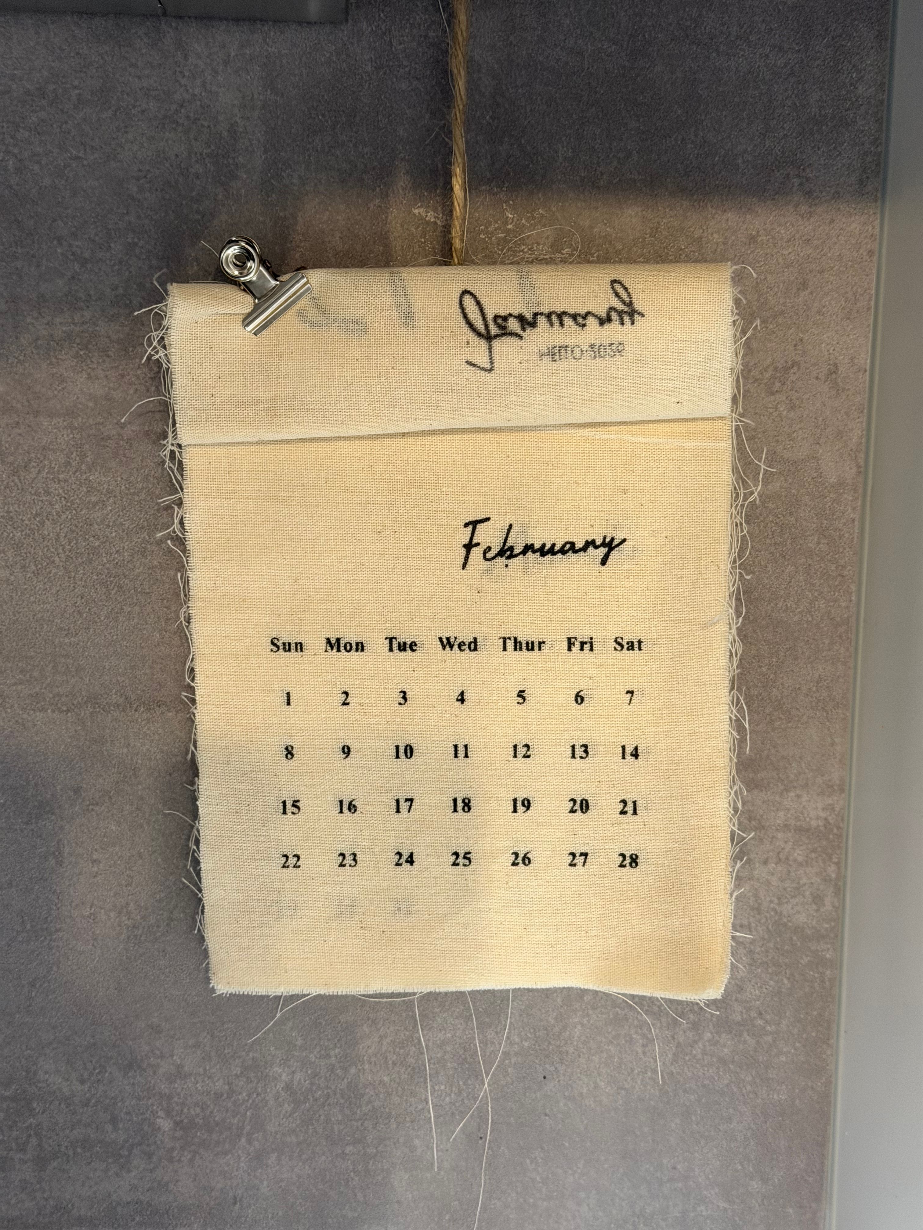 A handmade fabric calendar shows the month of February with a rustic style and minimalist design.