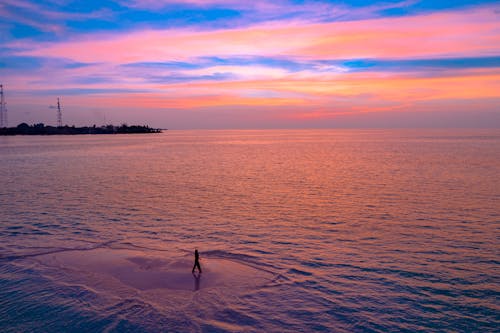 Schattenbild Der Person, Die Am Strand Während Des Sonnenuntergangs Geht