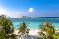 在碧绿海水的原始热带海滩上，鸟瞰一对夫妇