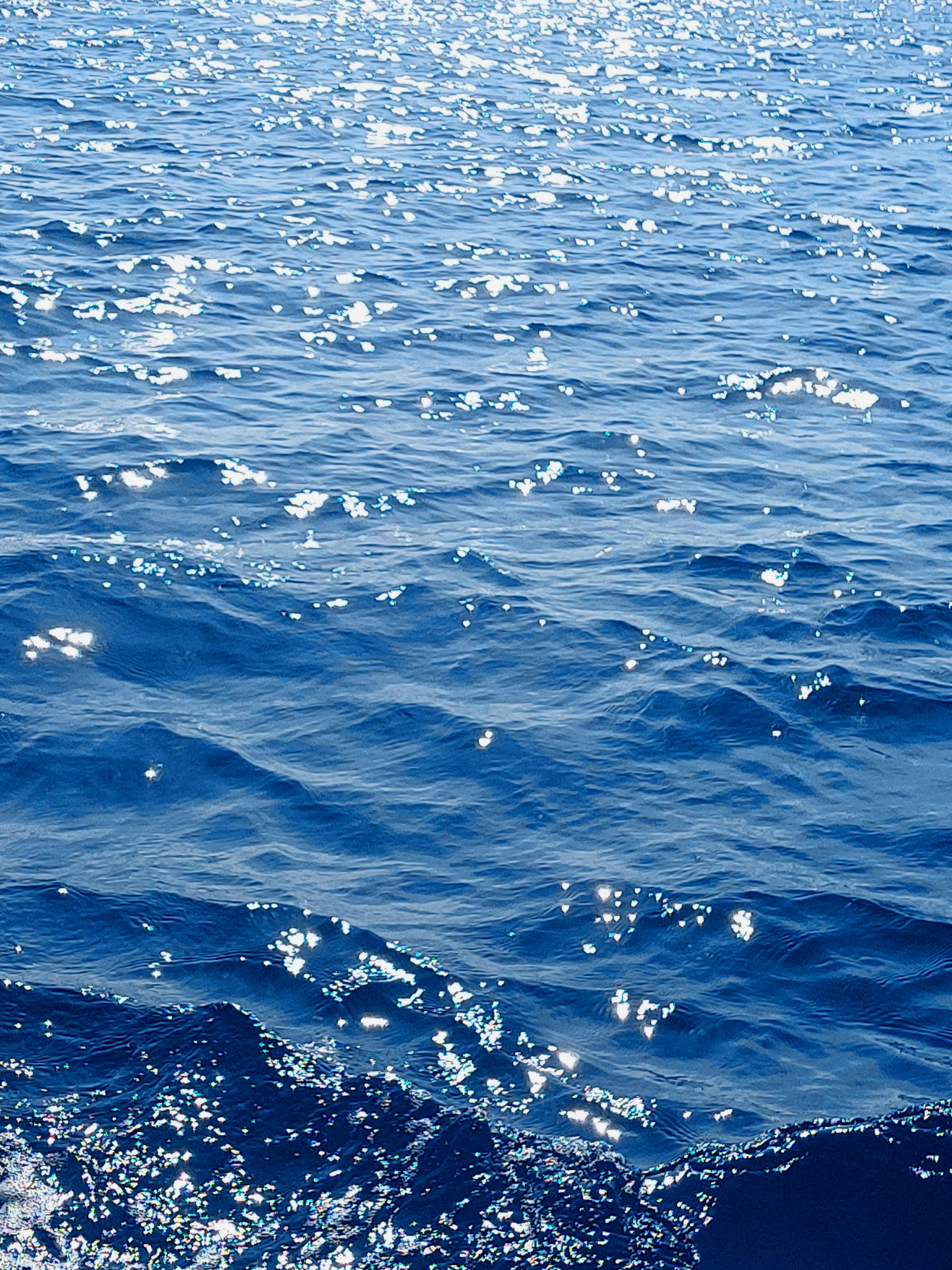 Sunlit ocean waves sparkling under clear skies in Jakarta, Indonesia.