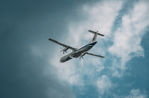 Free Airplane soaring high in the cloudy sky, showcasing modern aviation. Stock Photo