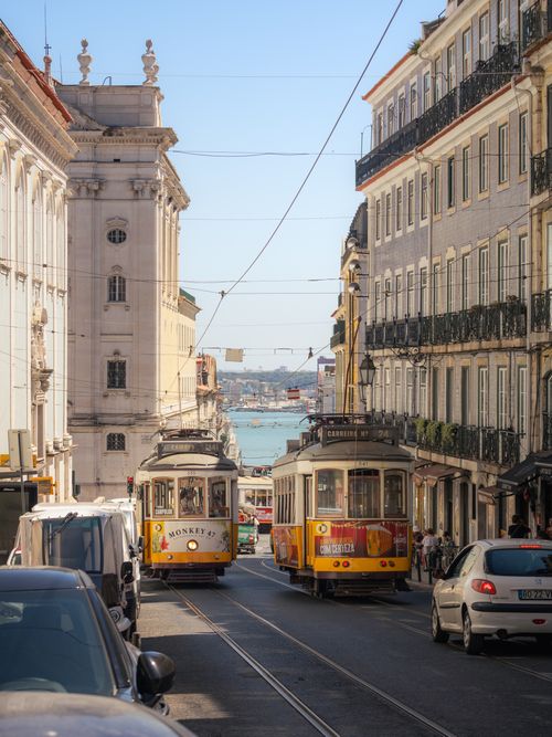 Free Charming Lisbon scene with vintage trams and classic architecture on a sunny day. Stock Photo