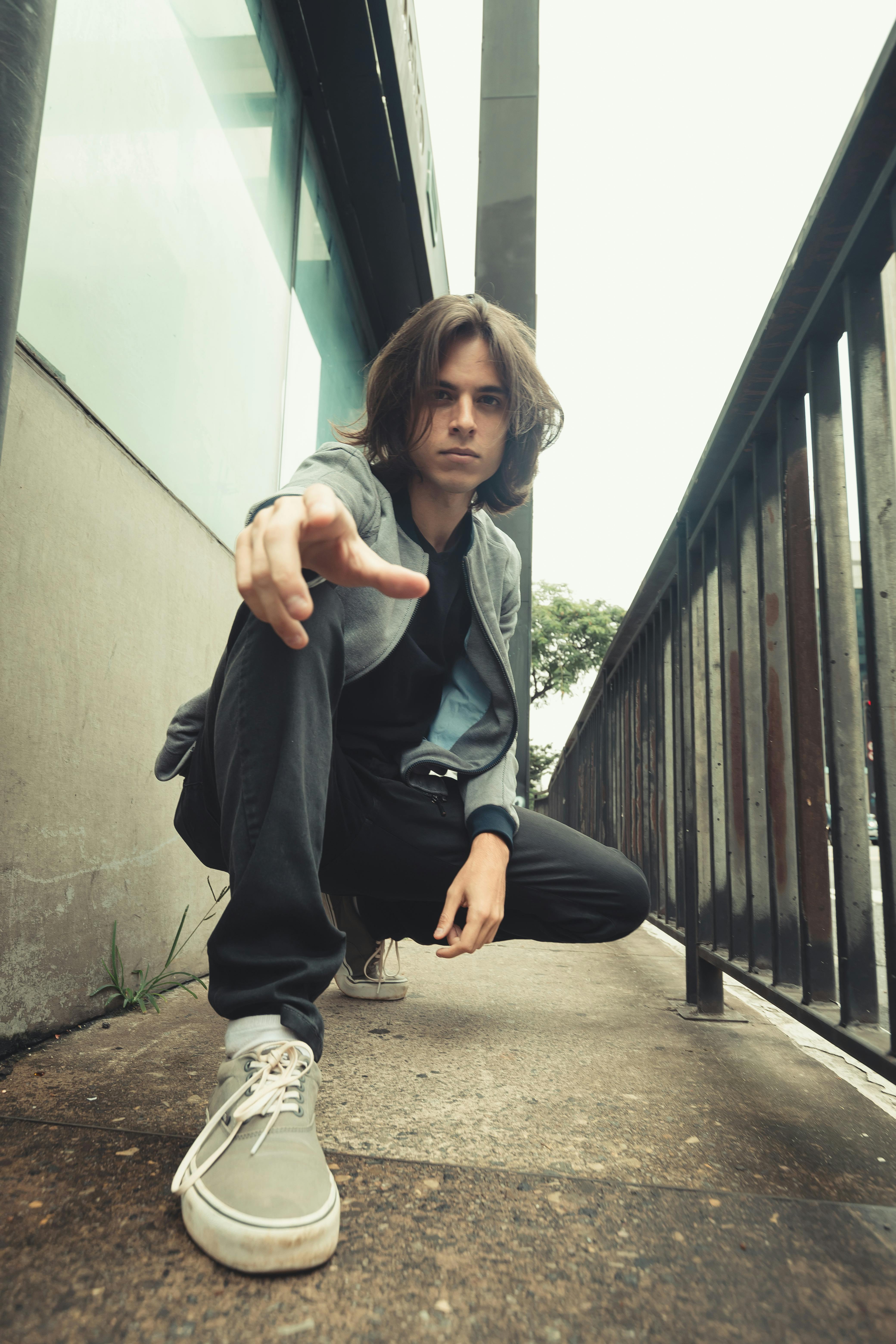 Candid portrait of a young adult male posing confidently on a São Paulo street.