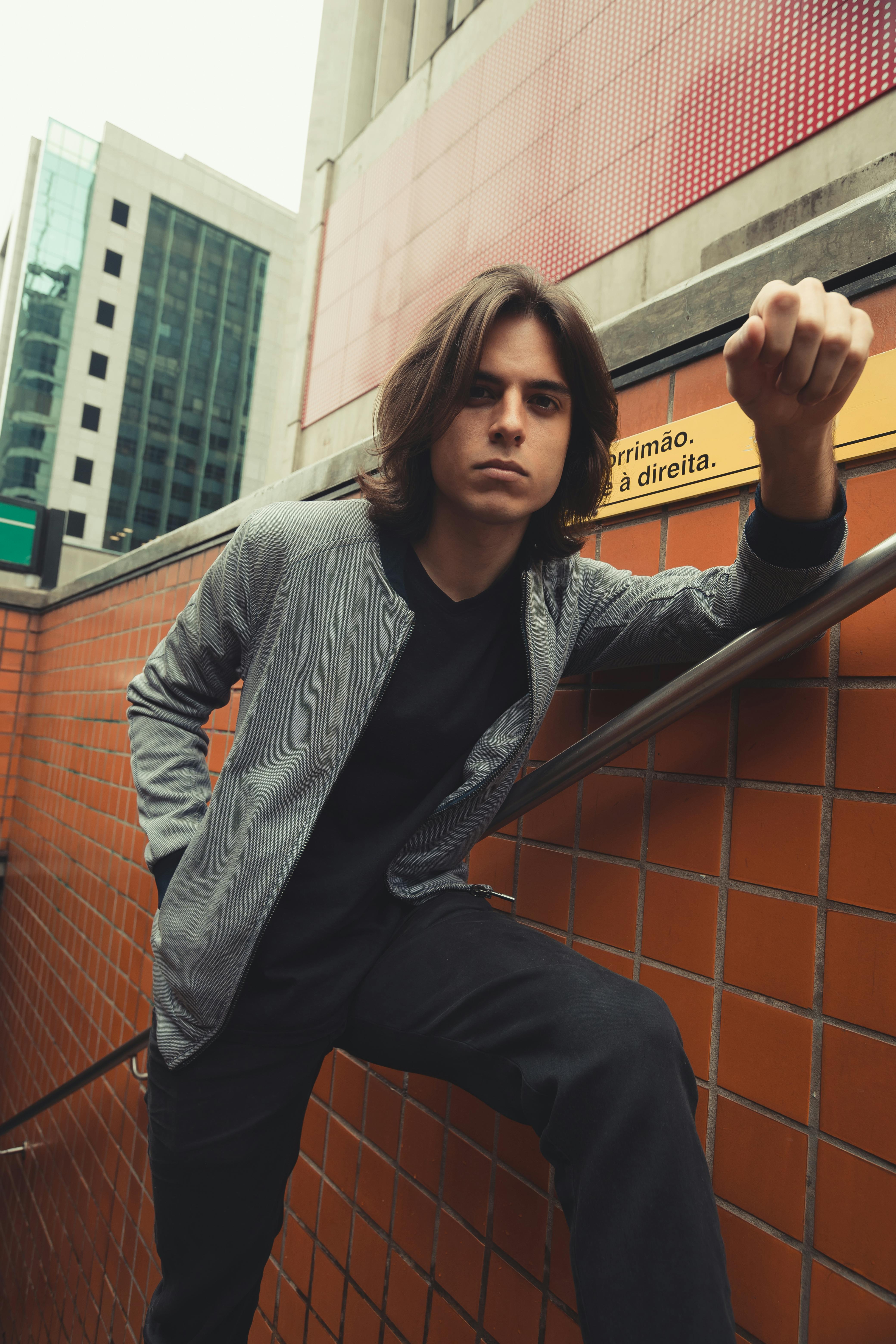 Stylish urban portrait of a young man in the São Paulo subway stairs.