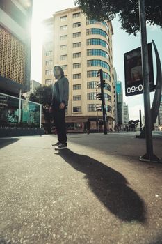 Dynamic street portrait of an adult in São Paulo, emphasizing urban life in a sunlit cityscape.