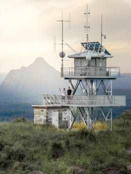 A scenic view of the lookout tower in Glass House Mountains, Queensland at sunset.