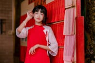 Young Woman in Red Dress Poses Near Vibrant Wall