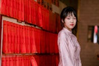 Young Woman in Traditional Dress by Red Envelopes