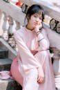 Young Woman in Pink Ao Dai Sitting on Stairs