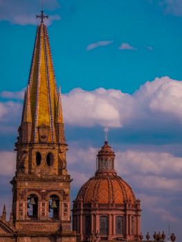 A stunning view of Guadalajara Cathedral with its iconic towers under a vibrant blue sky with clouds.