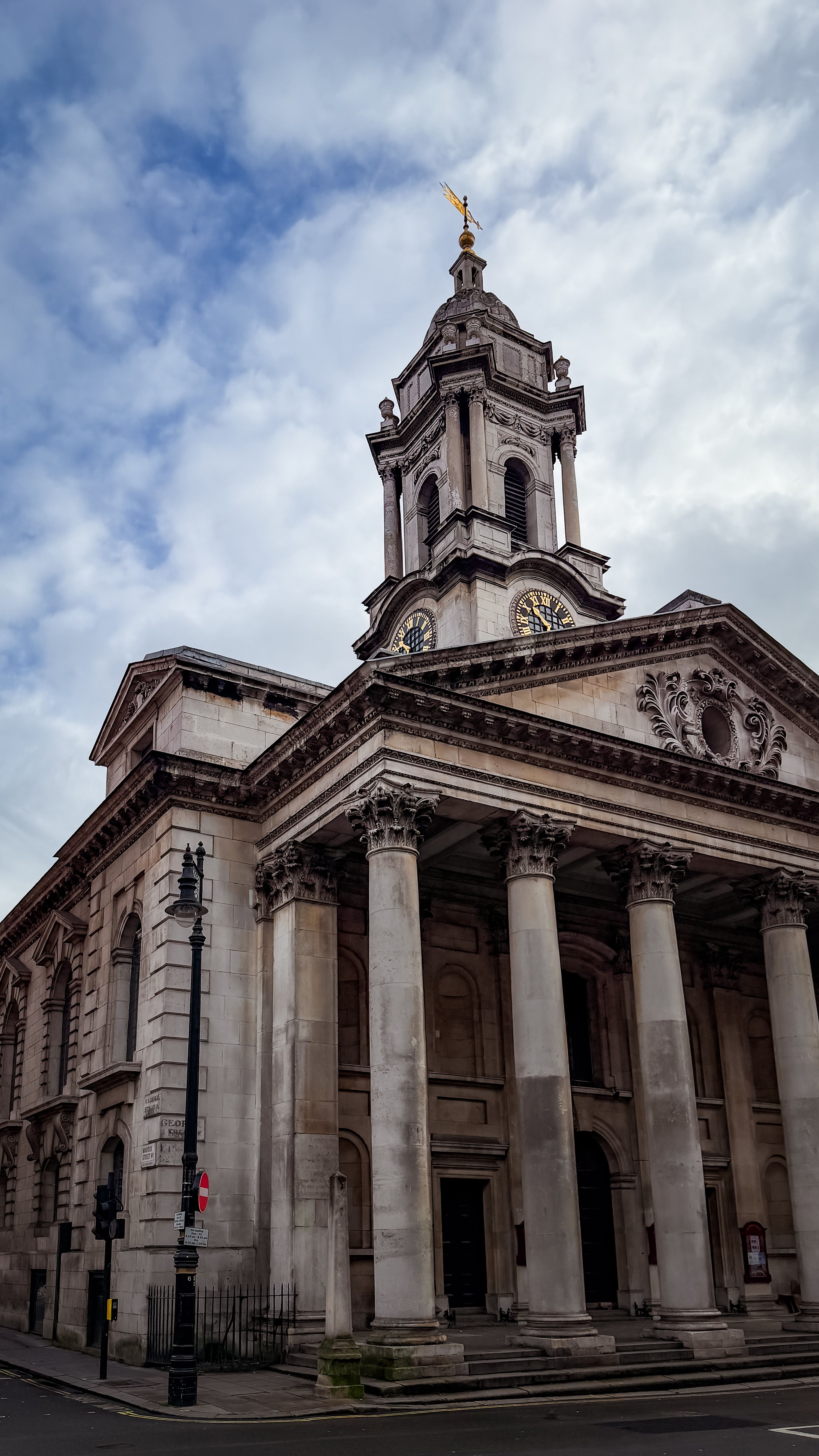 Elegant architecture of St. Martin-in-the-Fields Church in London against a cloudy sky.